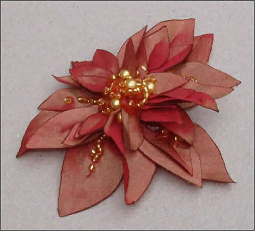 Blomst i r&oslash;d satin med perler